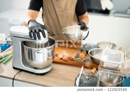 Male baker using a stand mixer to make cookie dough Male baker using a stand mixer to make cookie dough 122920589