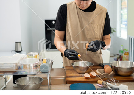 Baker separating eggs preparing for a delicious batch of homemade cookies Baker separating eggs preparing for a delicious batch of homemade cookies 122920590