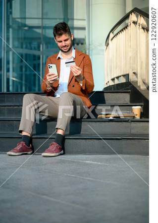 Businessman holding smartphone and credit card. Online banking and digital transactions concept 122920607