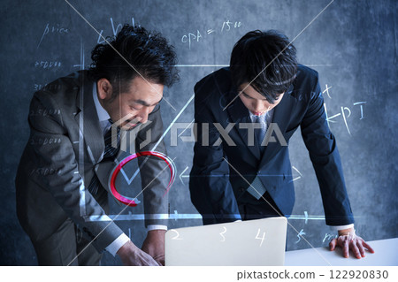 兩位西裝革履的商人看著電腦，思考廣告和行銷 122920830