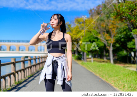 一位清涼的女子在河邊小徑散步補充水分 運動 有氧運動 修剪 一位清涼的女子在河邊小徑散步補充水分 運動 有氧運動 修剪 122921423