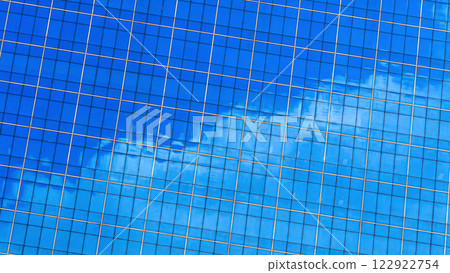 a vibrant blue glass facade with golden gridlines, reflecting the sky and creating a striking, modern architectural design. 122922754