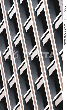 A modern architectural facade with repetitive geometric patterns, enhanced by dynamic light and shadow. The diagonal composition adds depth and a sleek, minimalist appeal. 122922770
