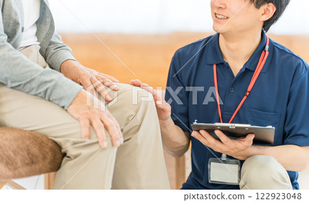 為老人提供諮詢的亞洲男性物理治療師/按摩治療師 122923048