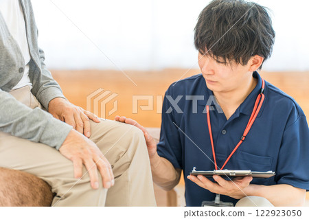 Asian male physiotherapist/massage therapist counseling senior man Asian male physiotherapist/massage therapist counseling senior man 122923050