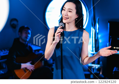 Female vocalist singing on stage 122924120