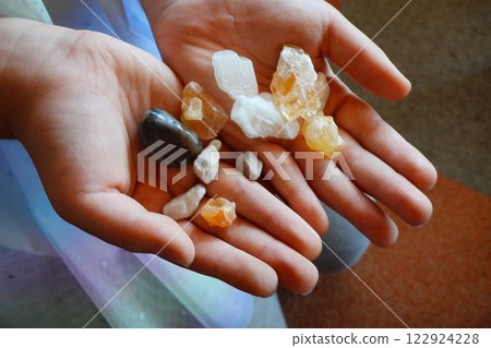 Trying out a gem hunt. Lots of small natural stones in a child's palm Trying out a gem hunt. Lots of small natural stones in a child's palm 122924228