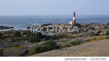 Eigeroy lighthouse, rock formations and ocean, Norway. 122925391
