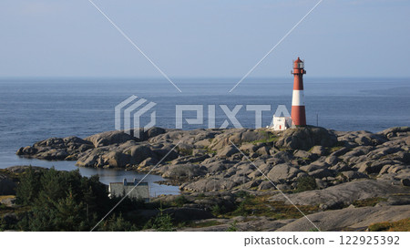 Eigeroy lighthouse, rock formations and sea, Norway. 122925392