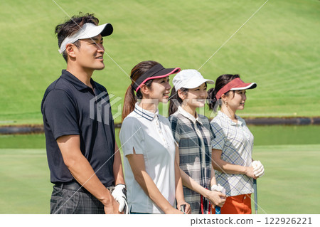 在高爾夫球場打高爾夫球的男女高爾夫球手 在高爾夫球場打高爾夫球的男女高爾夫球手 122926221