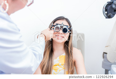 Smiling patient with optometrist trial frame. Closeup of optometrist examining patient with optometrist trial frame Smiling patient with optometrist trial frame. Closeup of optometrist examining patient with optometrist trial frame 122926294