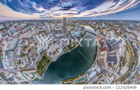 Yekaterinburg city and pond aerial panoramic view at summer or early autumn sunset. Night city in the early autumn or summer. Yekaterinburg city and pond aerial panoramic view at summer or early autumn sunset. Night city in the early autumn or summer. 122926406