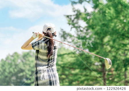 A golfer's woman playing golf on a golf course (tee shot/golf competition) 122926426