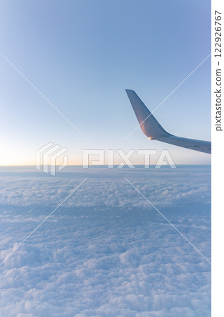 Beautiful salmon dawn and the wing of an airplane above the clouds. 122926767