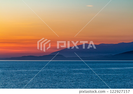 Scenic sunrise on the ocean with mountain views 122927157