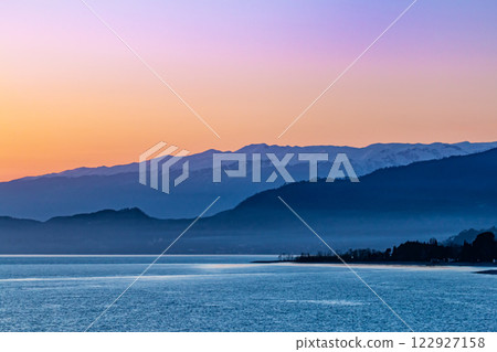 Picturesque sunset on the sea with mountain views Picturesque sunset on the sea with mountain views 122927158