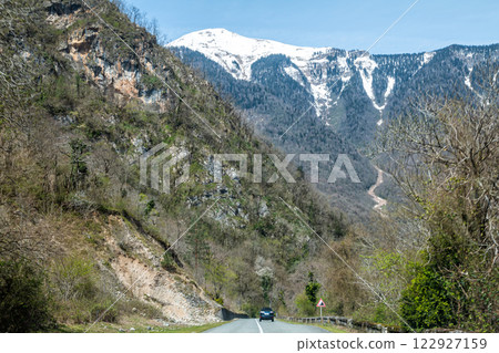 Road among picturesque snow capped mountain peaks Road among picturesque snow capped mountain peaks 122927159