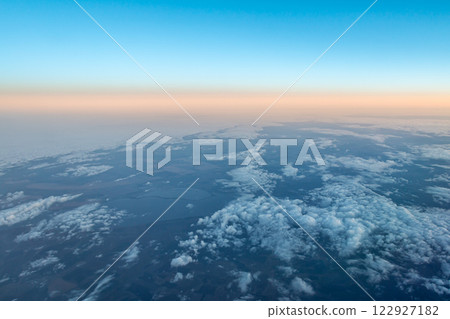 View of the earth and clouds from an airplane against the backdrop of the evening belt of Venus 122927182