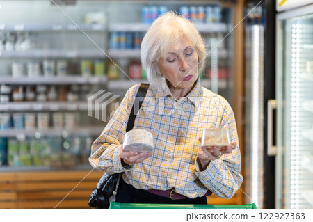 Elderly woman choosing cheese in grocery supermarket 122927363