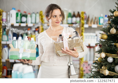 In household chemicals store, woman examines composition of shower cosmetic kit, X Mas gift set 122927471