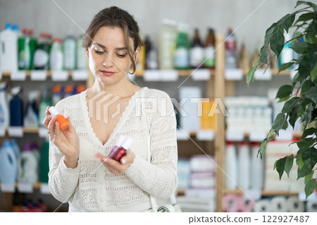 Housewife purchases household chemicals in store and chooses nail polish 122927487