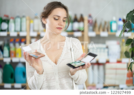 Young woman choosing eyeshadow in store 122927499