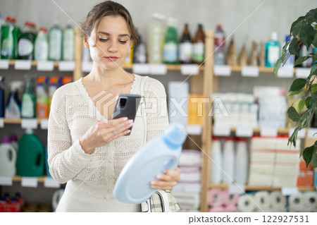 Young woman scanning qr code for detergent 122927531