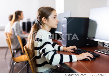 Portrait of schoolgirl at computers in university computer class 122927605