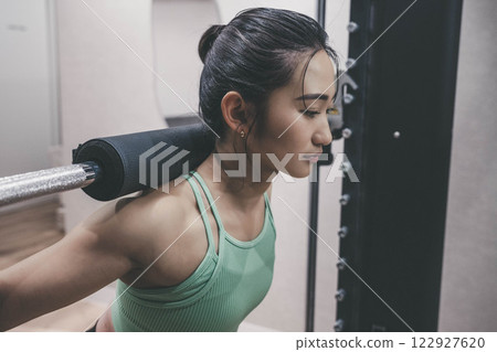 Young woman doing strength training in an indoor gym Young woman doing strength training in an indoor gym 122927620