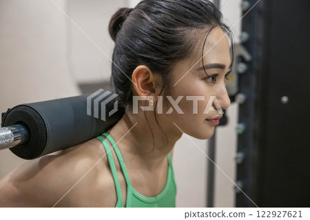 Young woman doing strength training in an indoor gym 122927621