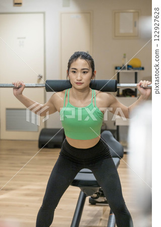 Young woman doing strength training in an indoor gym 122927628