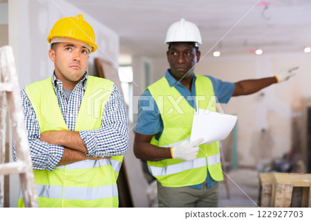 Portrait of confused man builder in construction site 122927703