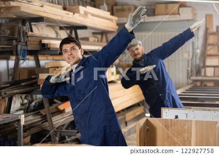 Young men doing exercises in wood workshop Young men doing exercises in wood workshop 122927758