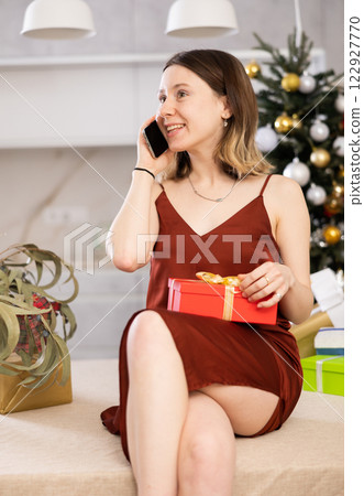 Cheerful woman is discussing something with someone on mobile Cheerful woman is discussing something with someone on mobile 122927770