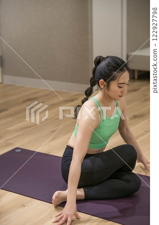 A young woman stretching in training clothes indoors A young woman stretching in training clothes indoors 122927798