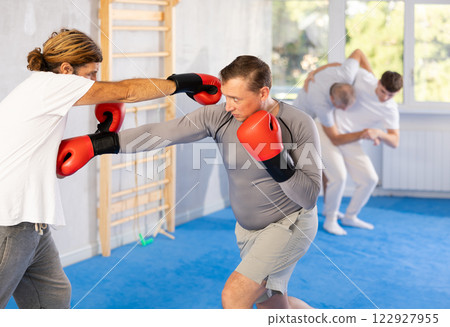 Two men training boxing fight in studio Two men training boxing fight in studio 122927955