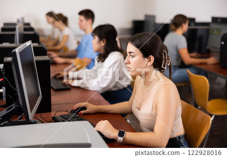 Portrait of interested teen girl during lesson in computer room of school class Portrait of interested teen girl during lesson in computer room of school class 122928016