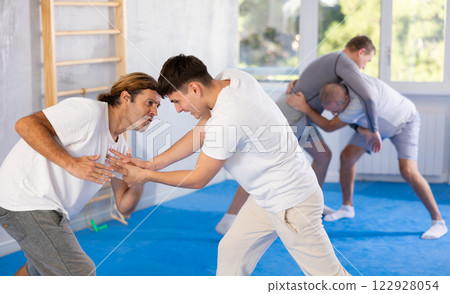 Two men training judo technique in studio Two men training judo technique in studio 122928054