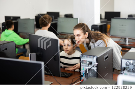 Female teacher and teenage girl looking at monitor of PC Female teacher and teenage girl looking at monitor of PC 122928239