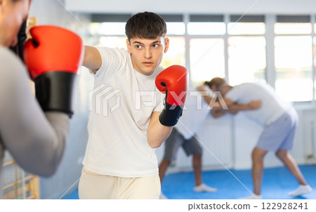 Two men in boxing training perform sparring and one man blocked blow 122928241