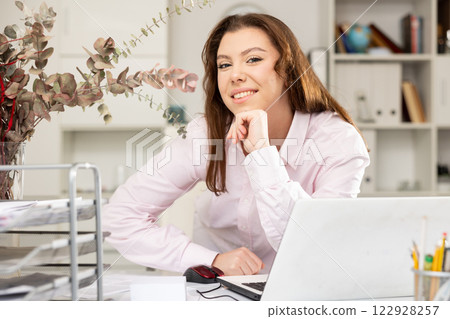 Portrait of positive female secretary in her workplace Portrait of positive female secretary in her workplace 122928257