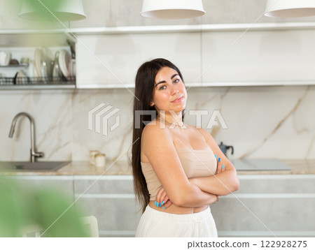 Young smiling woman posing in kitchen at home 122928275