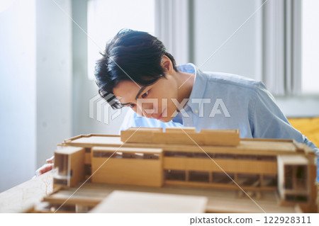 一所工程大學的男性建築系學生正在製作建築模型，臉上帶著嚴肅的表情。 122928311