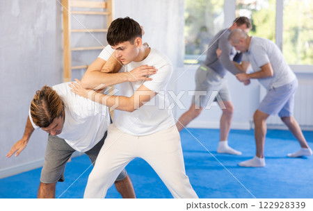 Young guy and man practice wrestling, apply techniques of Aikido and self-defense. 122928339