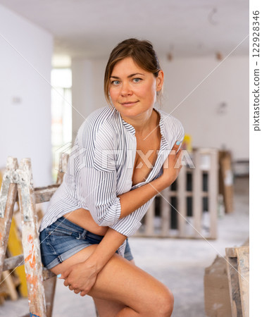 Young seductive woman posing in apartment during repair works 122928346