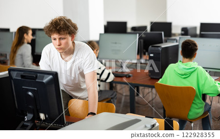 Teenage boy using computer during lesson Teenage boy using computer during lesson 122928355