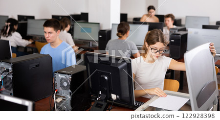 Focused girl using scanner in computer room Focused girl using scanner in computer room 122928398