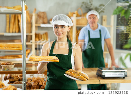 Young smiling woman baker offers to buy fresh delicious bocadillo 122928518