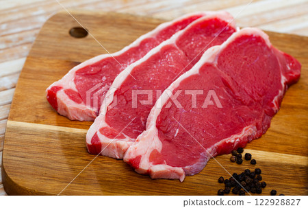 close up of pieces of marbled beef on wooden table close up of pieces of marbled beef on wooden table 122928827