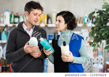 Female consultant helps man buyer choose shower gel 122928828
